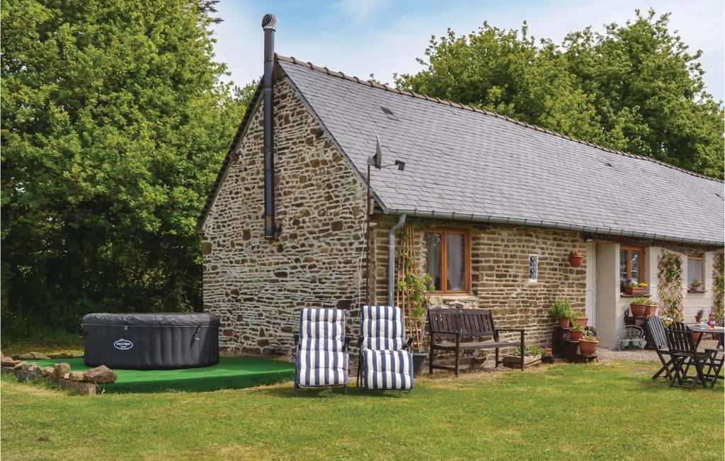 un cottage en briques avec des chaises, une table et des chaises dans l'établissement Stunning Home In Fougerolles Du Plessis, à Fougerolles-du-Plessis