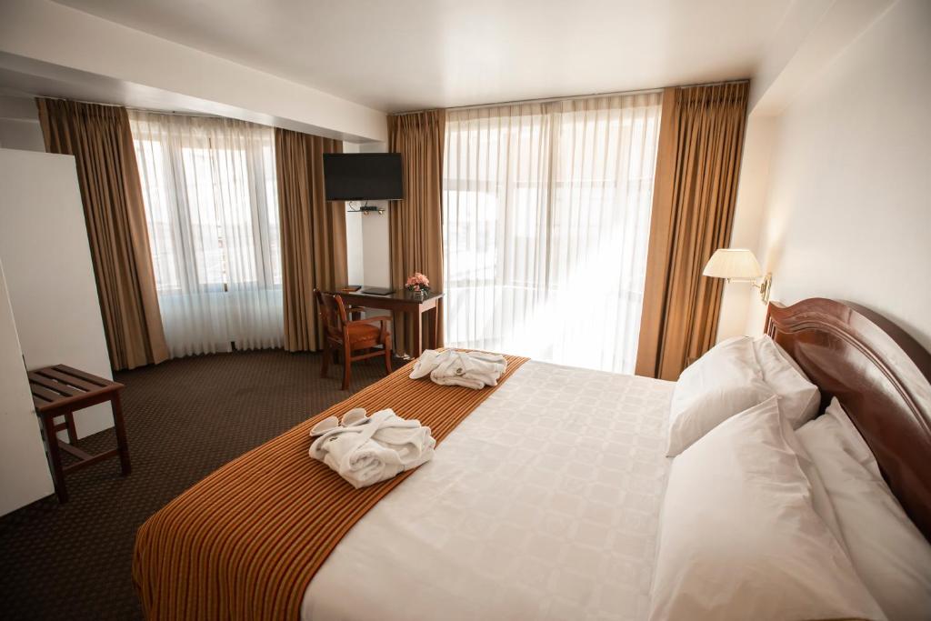 a hotel room with a bed with towels on it at Hotel Hacienda Puno Centro Histórico in Puno