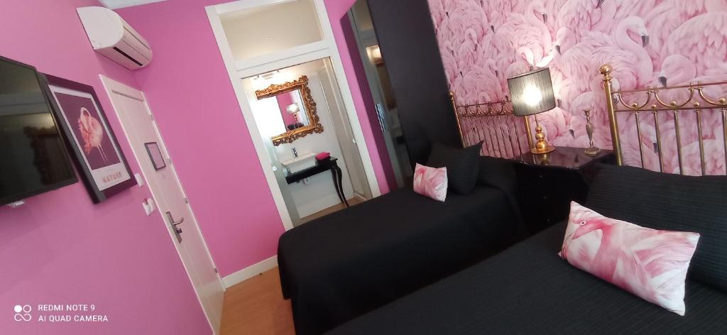 a bedroom with a bed and a pink wall at Alojamiento Buciero in Santoña