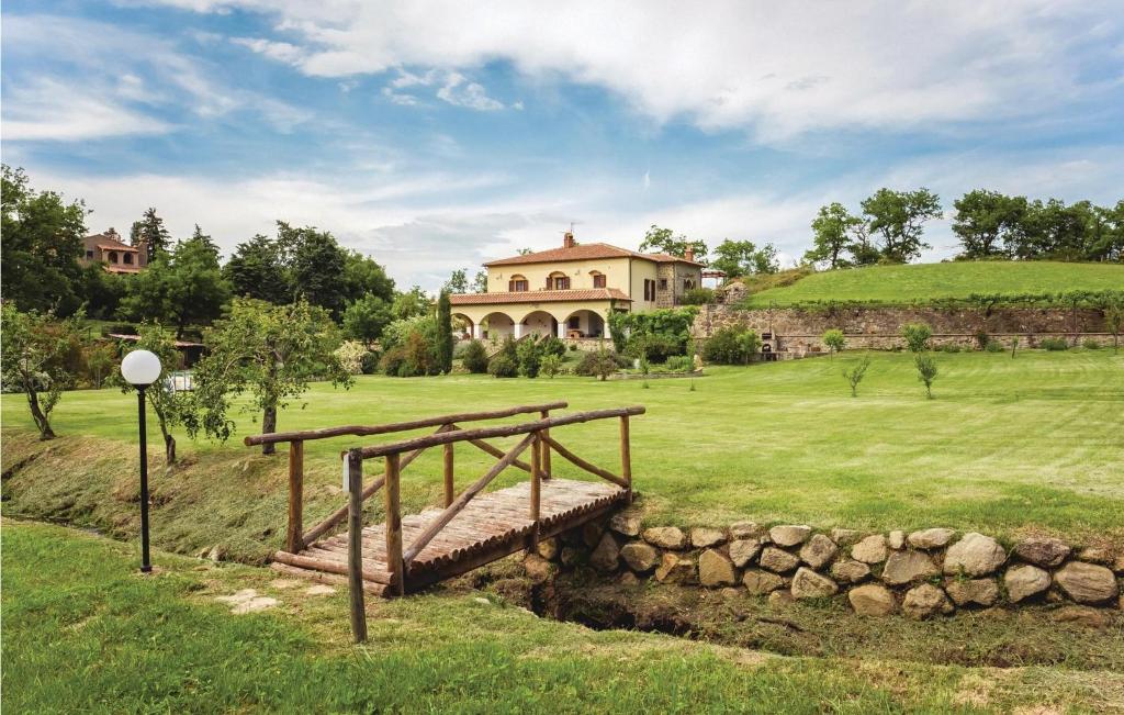 a house with a bridge over a river in a field at Casale S, Giacomo in Castel del Piano