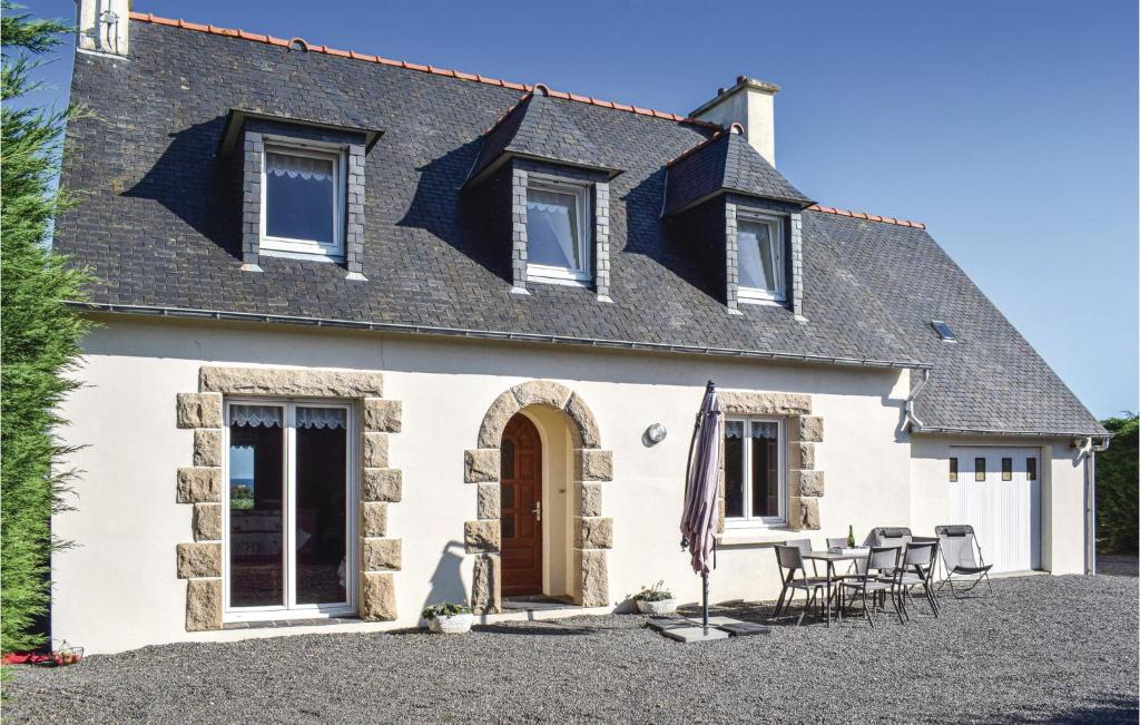 a cottage with a table and chairs in front of it at Stunning Home In Kerbors With House Sea View in Kerbors