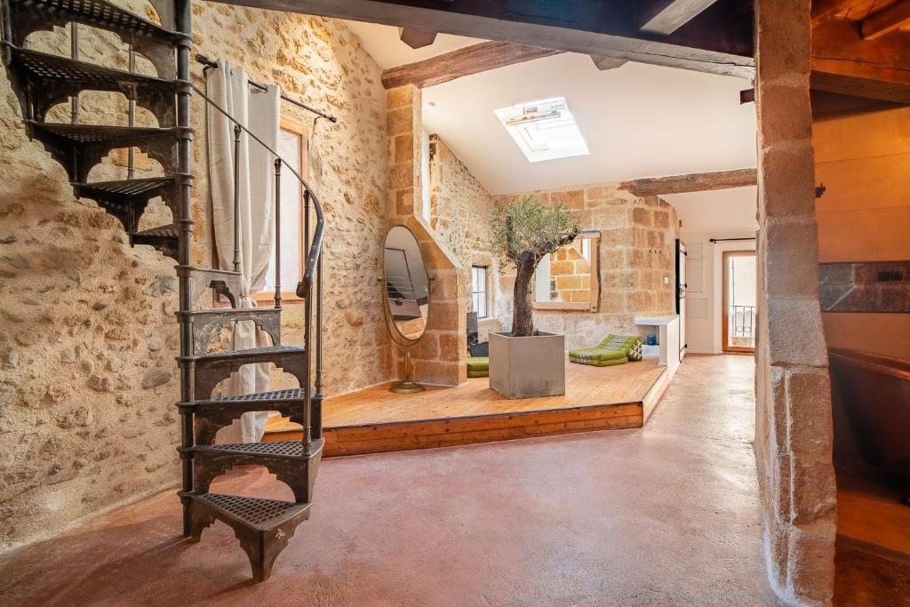 a room with brick walls and a spiral staircase at L'Olivier Loft HH Centre Corum - Netflix & Prime Video 4k in Montpellier