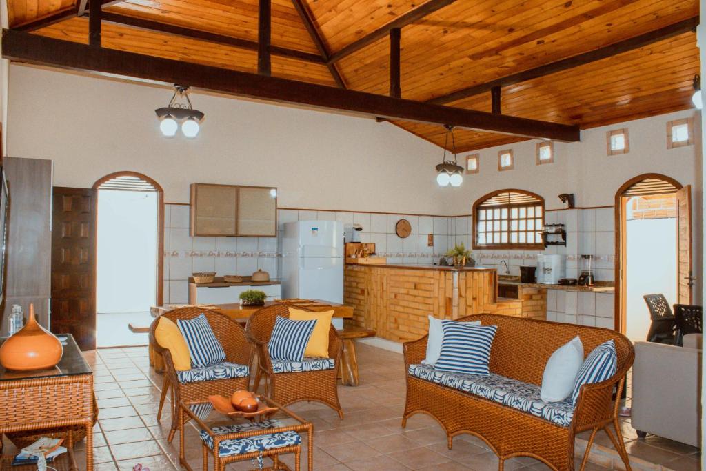 a kitchen and living room with chairs and a table at casa em Barra de Cunhaú-RN in Barra do Cunhau