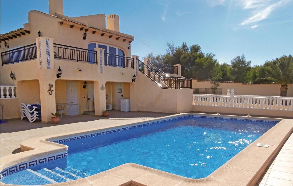 Villa con piscina frente a una casa en Awesome Home In Orihuela Costa With 4 Bedrooms, Wifi And Outdoor Swimming Pool en Playas de Orihuela