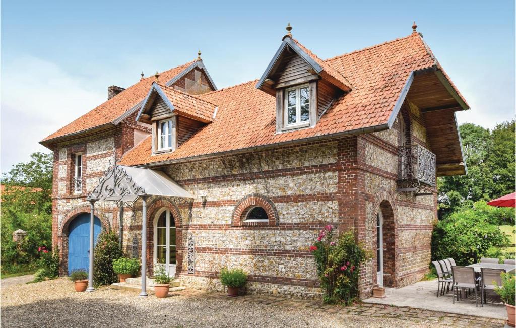 una antigua casa de ladrillo con techo rojo en 6 Bedroom Awesome Home In Hericourt-en-caux, en Héricourt-en-Caux