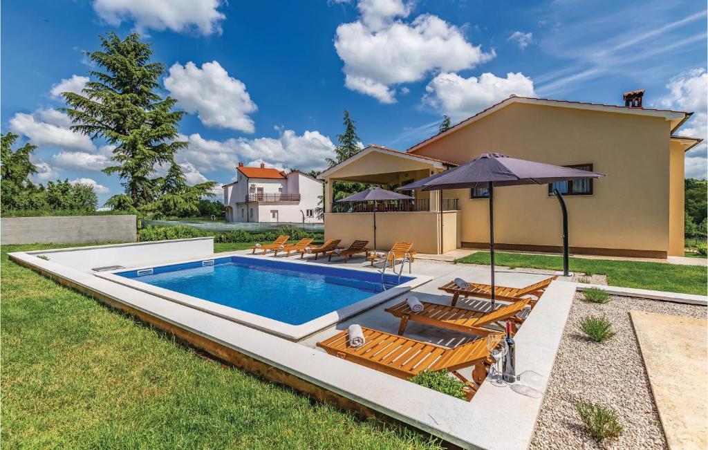 una piscina con sillas y sombrilla en Amazing Home In Pazin With Wifi en Pazin