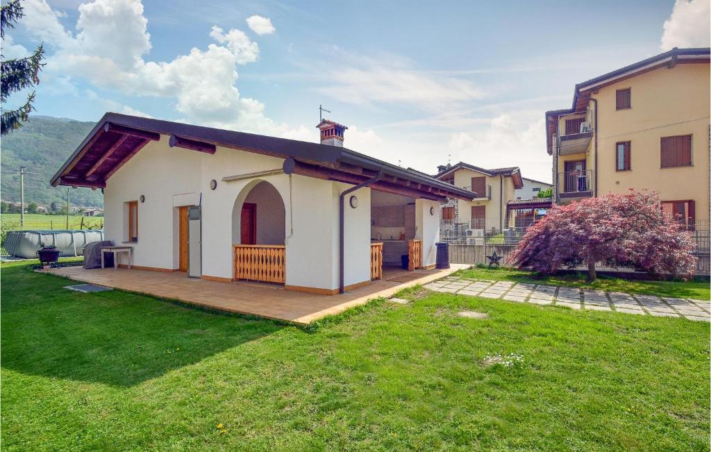 uma pequena casa branca com um grande quintal em La Gallina em Artogne