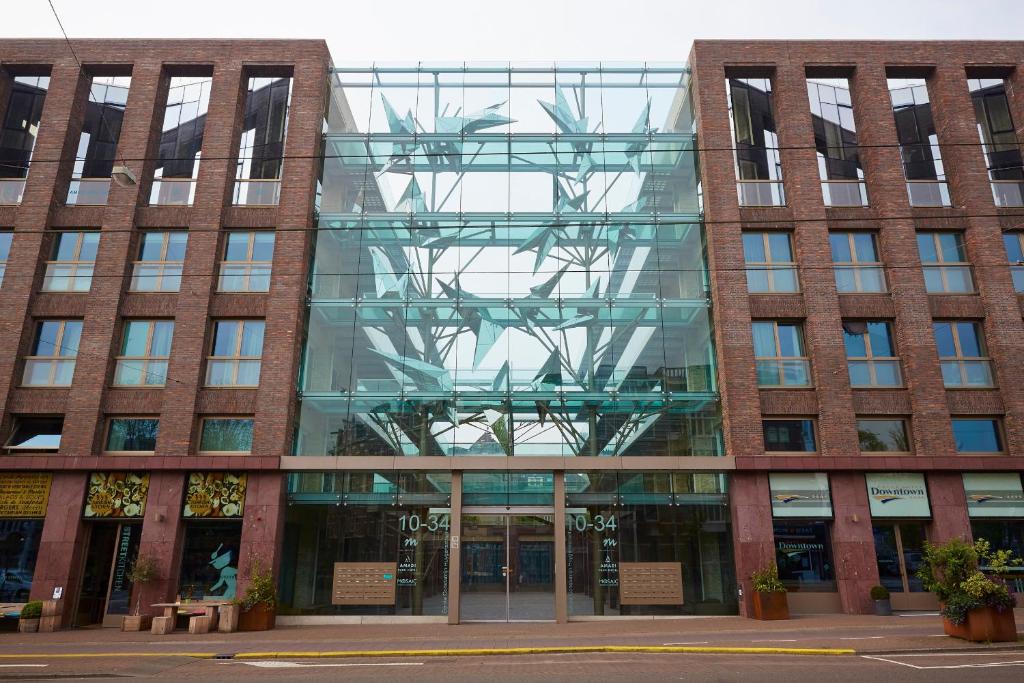 een groot bakstenen gebouw met een glazen gevel bij Amadi Park Hotel in Amsterdam