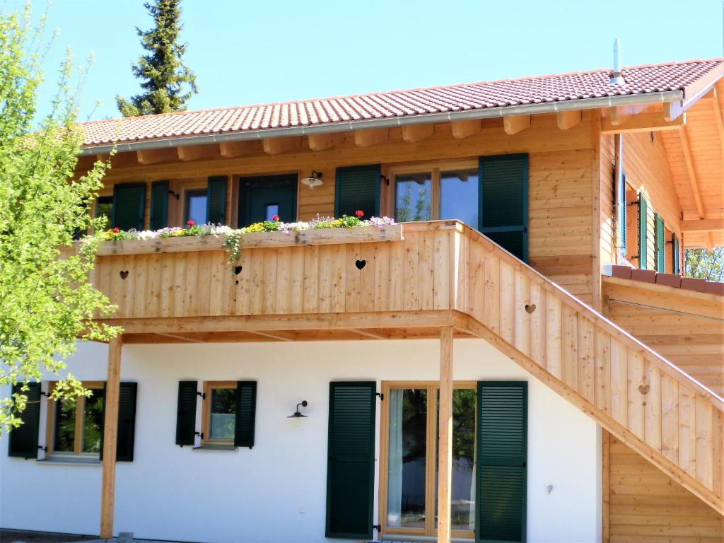 a wooden house with green shutters and a deck at Ferienhaus Inntal in Kiefersfelden