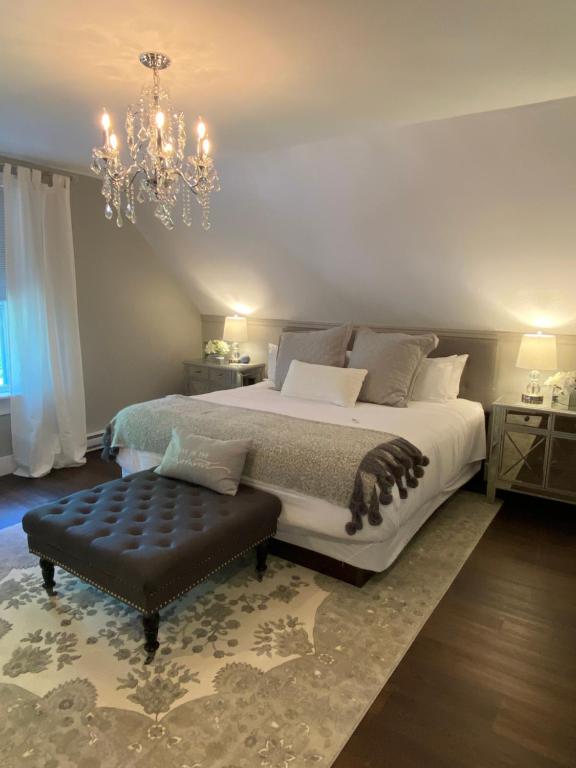 a bedroom with a large bed and a chandelier at Beach Street Inn in St. Martins