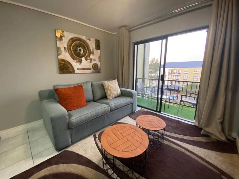 un soggiorno con divano e 2 tavoli di Insaka's Greenlee 3 Luxurious Apartment a Avalon
