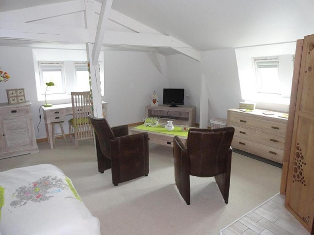 - une chambre avec un lit et un bureau avec des chaises dans l'établissement l'Améthyste, à Saumur