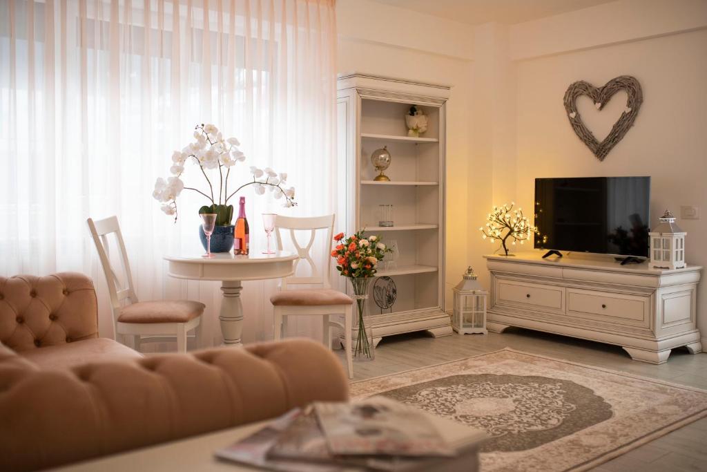 a living room with a couch and a tv and a table at Căsuța din Copou in Iaşi