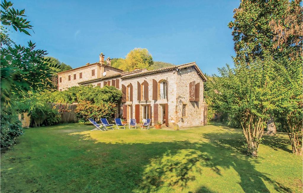 una antigua casa de piedra con sillas en un patio en Il Glicine, en Galzignano Terme