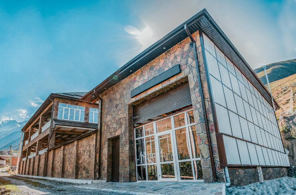 un edificio con ventanas grandes en un lateral en Mountain Saniba Eco Hotel en Staraya Saniba