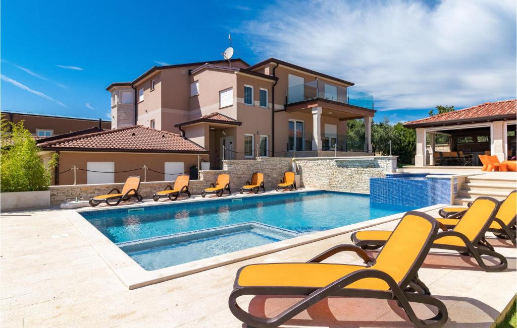 - une piscine avec des chaises et une maison dans l'établissement 7 Bedroom Cozy Home In Valtura, à Valtura