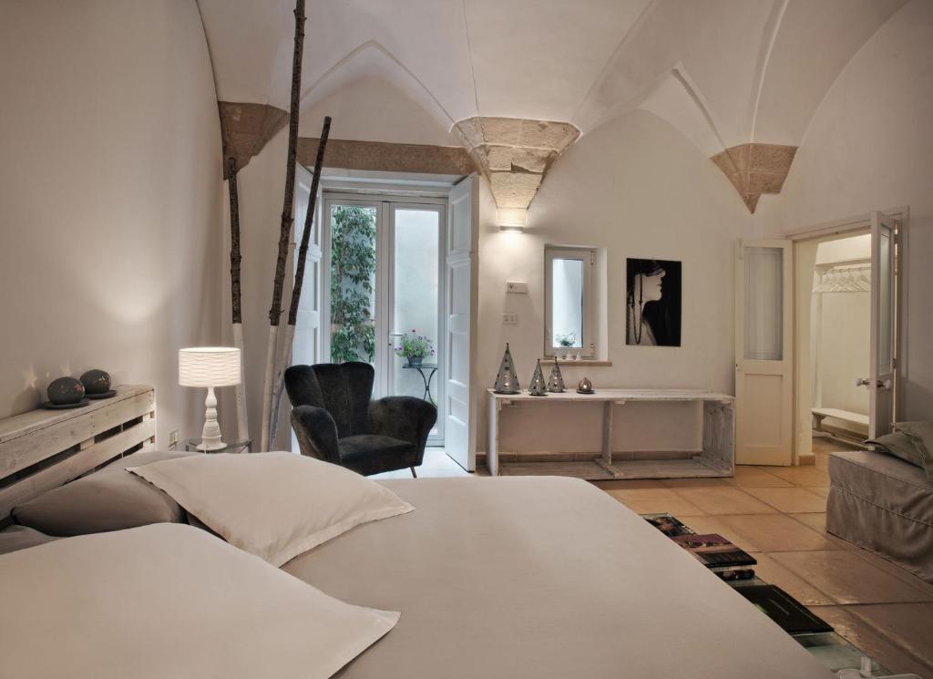a bedroom with a white bed and a bathroom at Corte dei Romiti Apartment in Lecce