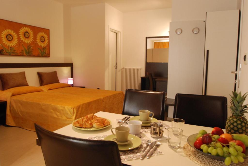 una habitación con una cama y una mesa con comida. en B&B Fiera Maglo', en Bolonia