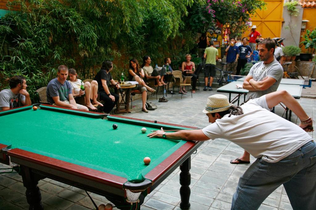 a man playing a game of pool in a courtyard at Kunming Cloudland International Youth Hostel in Kunming