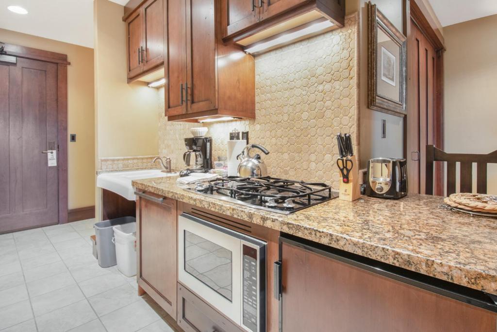 a kitchen with a stove and a counter top at Arrowleaf Lodge - 1 Bed Studio #101A in Park City