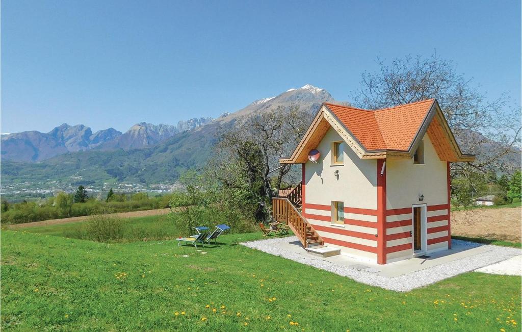 uma pequena casa num campo com montanhas ao fundo em Awesome Home In Belluno Bl With Wifi em Lèvego