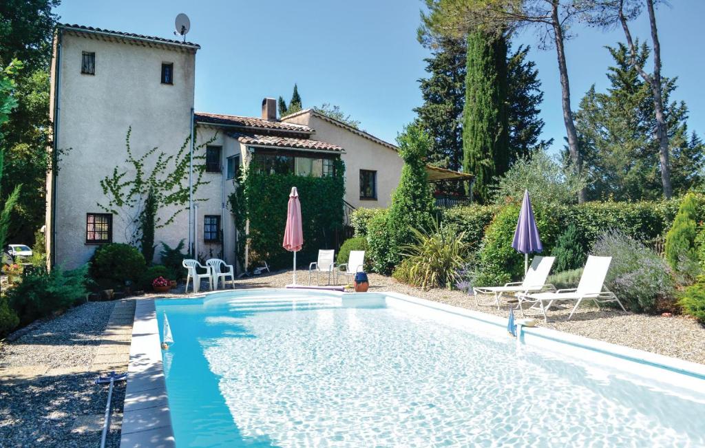 una piscina con sillas y sombrillas frente a una casa en Gorgeous Apartment In Lorgues With Kitchen, en Lorgues