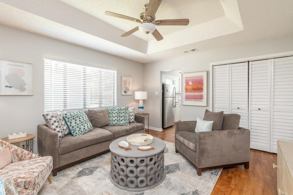 a living room with a couch and a ceiling fan at Shore to Please in Tybee Island