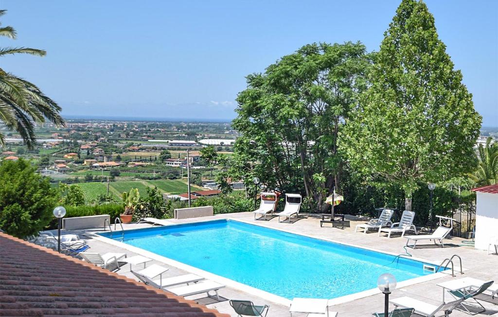 a swimming pool with chairs and a view of a city at Villa Emeliarco in Capaccio-Paestum