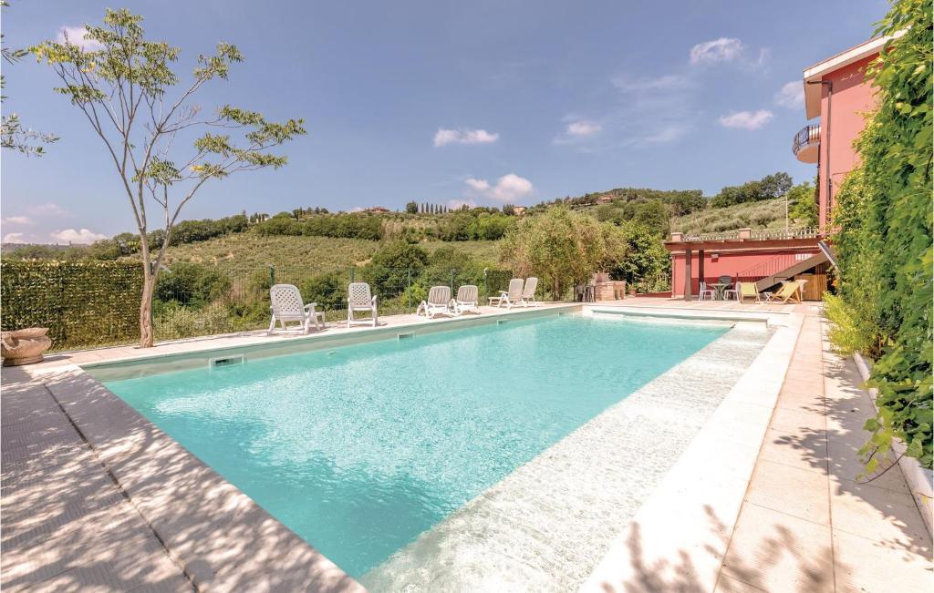 a swimming pool with chairs and a house at Nice Apartment In Perugia -pg- With Outdoor Swimming Pool in Ponte Felcino