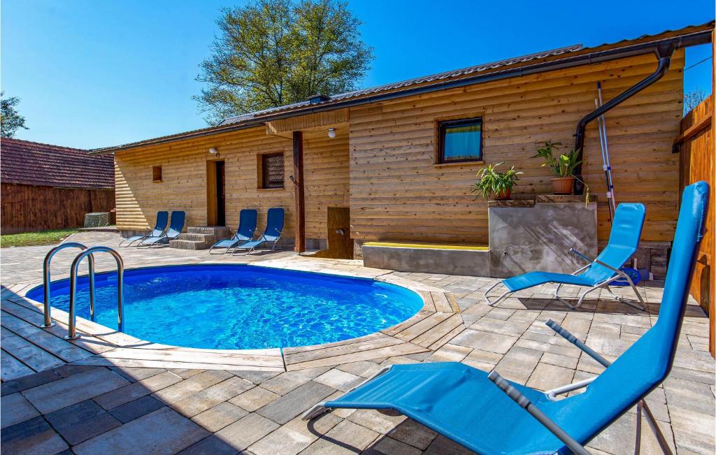 uma piscina com cadeiras e uma casa em Stunning Home In Tounj With House A Panoramic View em Tounj
