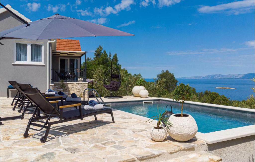 eine Villa mit einem Pool mit Stühlen und einem Sonnenschirm in der Unterkunft 1 Bedroom Beautiful Home In Blato in Blato