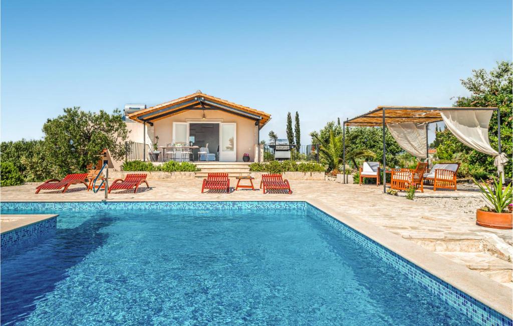 una piscina con sedie e una casa di Awesome Home In Sutivan With Private Swimming Pool, Outdoor Swimming Pool And Heated Swimming Pool a Sutivan (San Giovanni di Brazza)