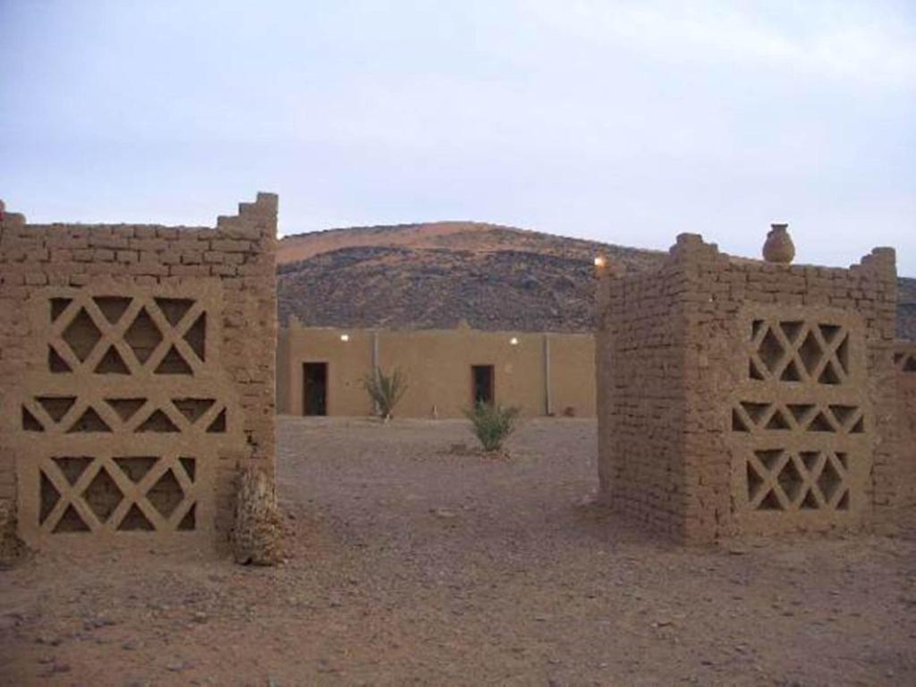 a building in the middle of a desert with two doors at Auberge Camping Tafraoute Montagnes in Tafraoute Sidi Ali