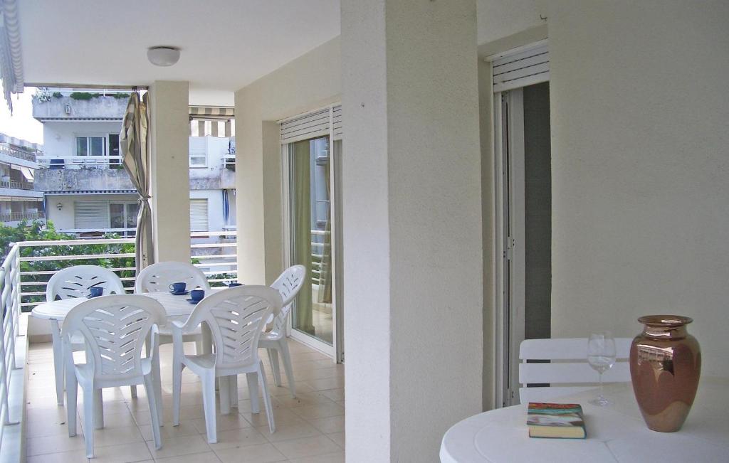 トッサ・デ・マールにあるAwesome Apartment In Tossa De Mar With 3 Bedroomsの白いダイニングテーブルと椅子付きのバルコニー