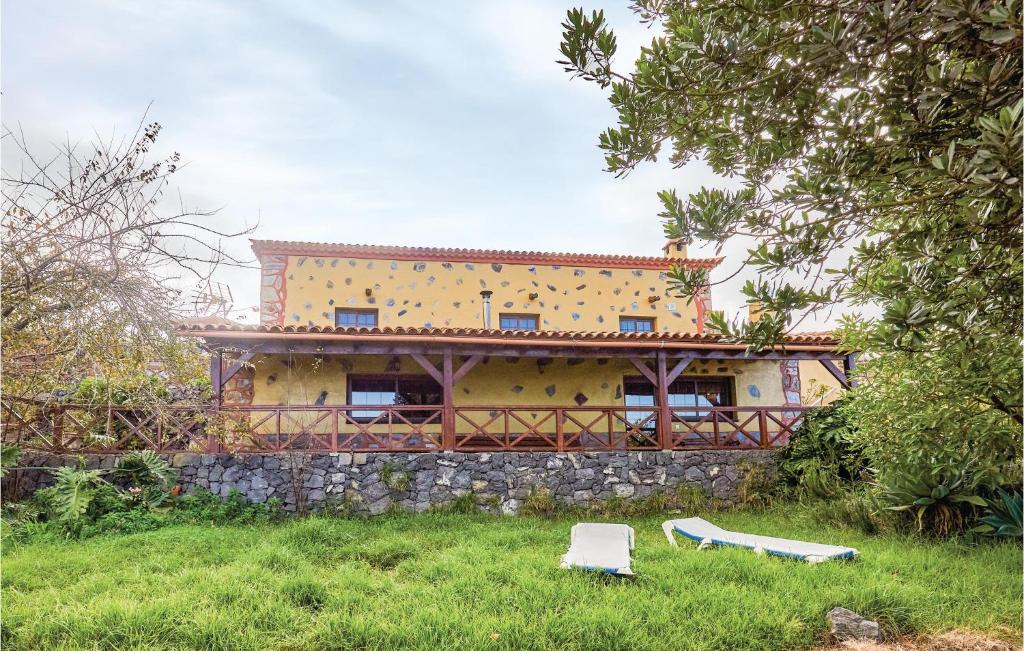 a yellow house with a stone wall in a field at Holiday Home Hoya Los Charcos in Icod el Alto
