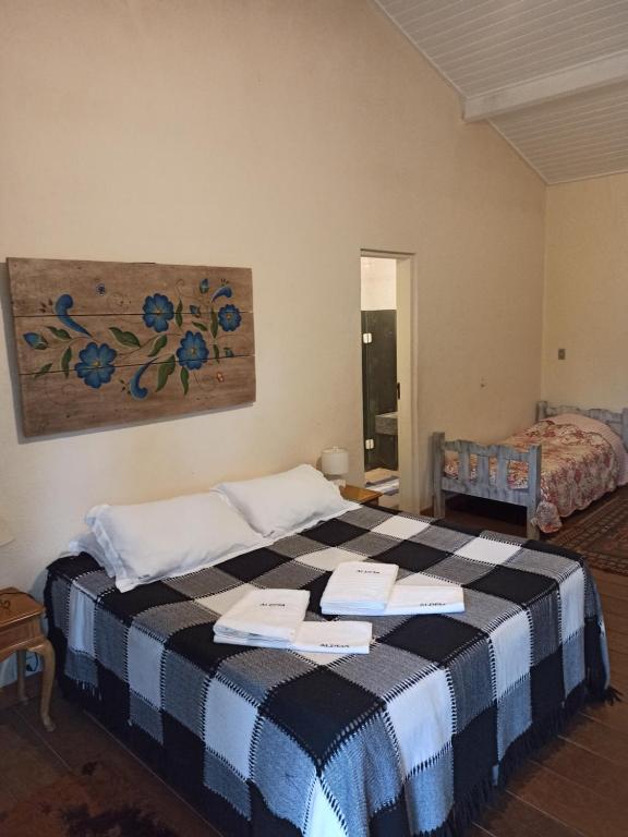 a bedroom with a bed with two papers on it at Aldeia Parque Pousada Rural in São Roque