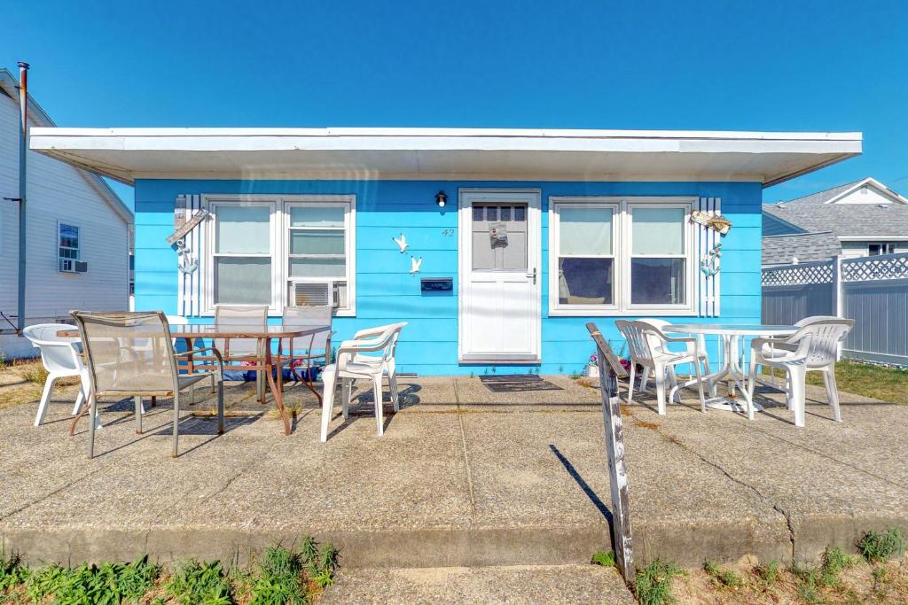 una casa azul con mesa y sillas en Beach Bungalow, en Seabrook