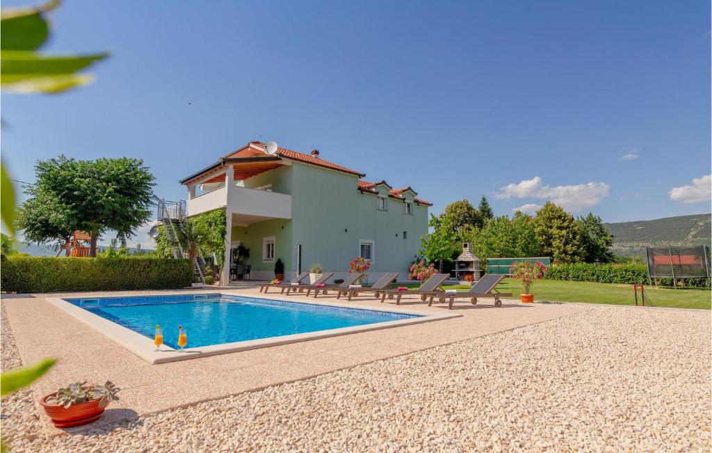 une villa avec une piscine en face d'une maison dans l'établissement Stunning Home In Donji Prolozac With Wifi, à Donji Proložac