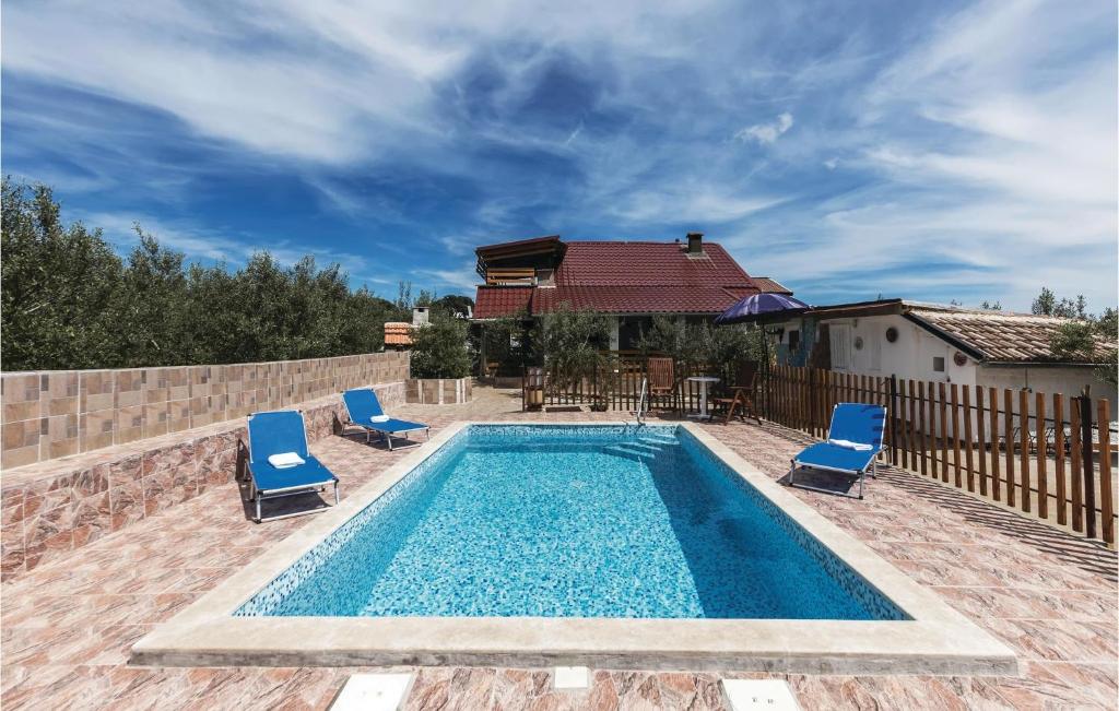 una piscina con sillas azules y una casa en Stunning Home In Valtura With Kitchen, en Valtura