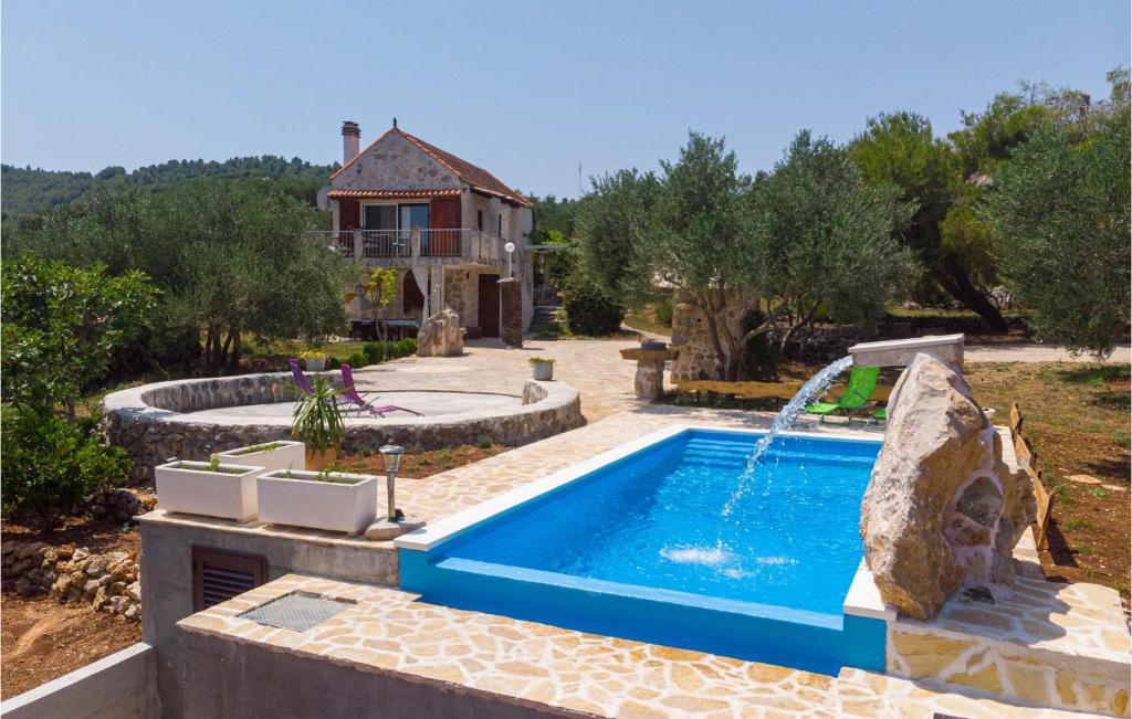 a swimming pool with a fountain in front of a house at Beautiful Home In Ston With Wifi in Ston