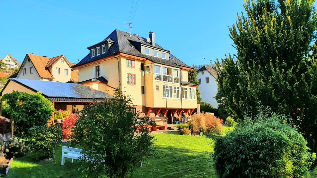 ein großes gelbes Haus mit schwarzem Dach in der Unterkunft Ferienwohnung Sägemühle in Unterreichenbach