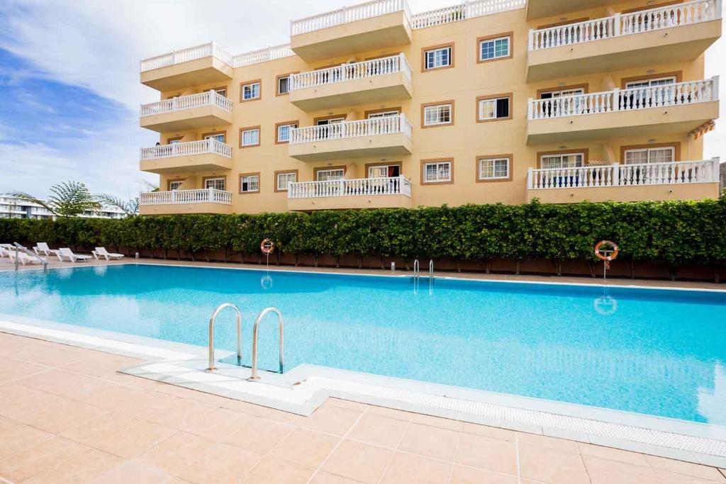 a hotel with a swimming pool in front of a building at Palm Mar de LUX A26 in Palm-Mar