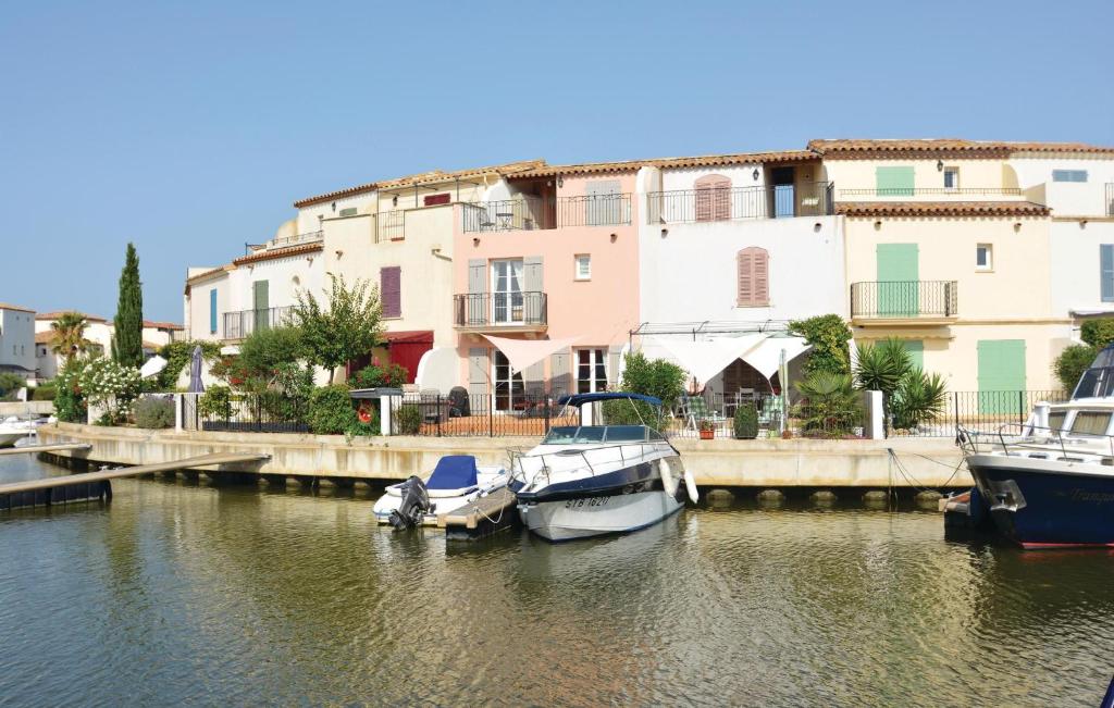 two boats docked in the water in front of a building at Beautiful Home In Aigues-mortes With 3 Bedrooms And Wifi in Le Grau-du-Roi