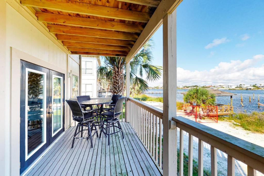a porch with chairs and a table on a balcony at Molokai Villas 7B in Pensacola