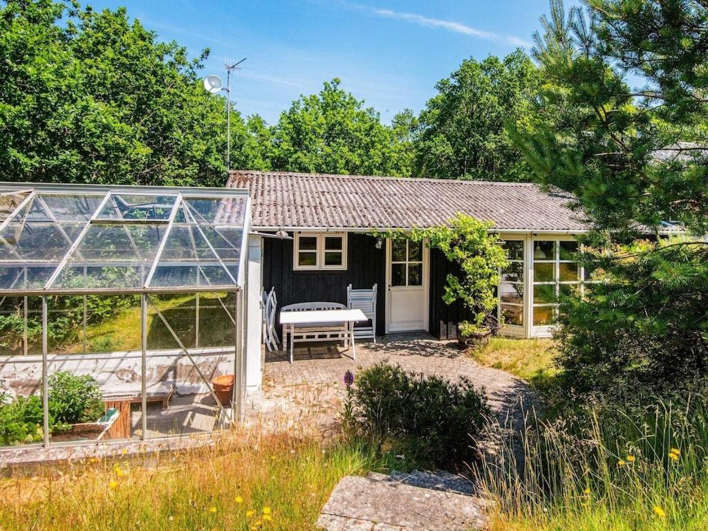 uma pequena casa com um jardim e um pátio em 6 person holiday home in Alling bro em Allingåbro