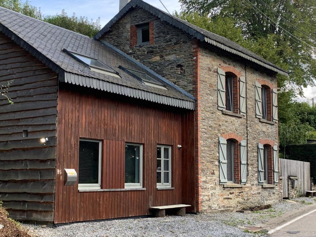 un petit bâtiment en briques avec des fenêtres et un banc dans l'établissement Maison de Rochehaut, à Rochehaut