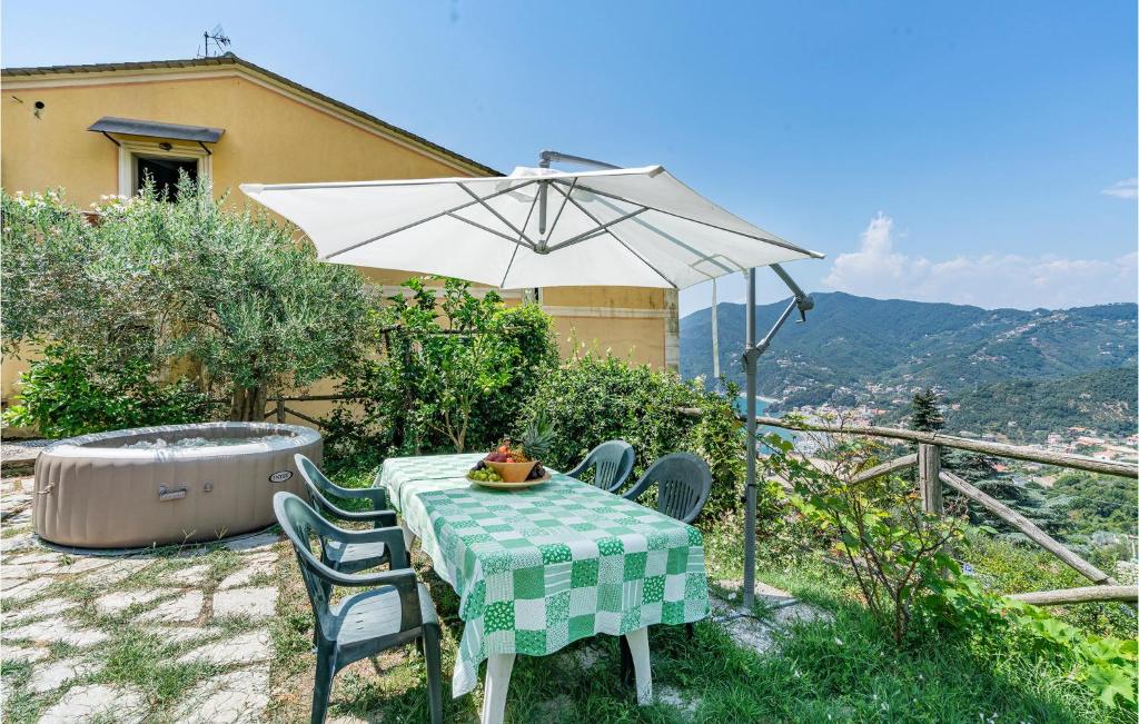une table et des chaises avec un parasol et un bain à remous dans l'établissement Awesome Home In Moneglia With Kitchen, à Moneglia