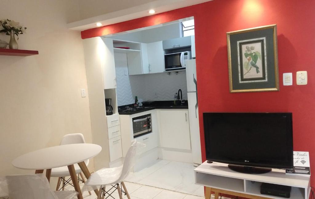 sala de estar con TV y pared roja en Quarto e sala silencioso em Copacabana, en Río de Janeiro