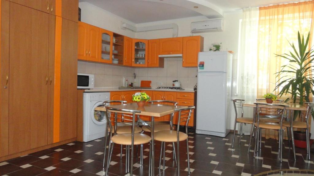 a kitchen with a table and chairs and a refrigerator at Guest House Romashka in Feodosia