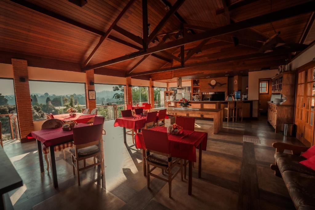 a dining room with red tables and chairs at Pousada Marco Polo in Campos do Jordão